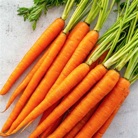 Remove carrot green stems and chop garlic: When greens are dry, remove stiff stems and finely chop the garlic cloves. Sauté the greens: To a medium pan heat olive oil over medium-low heat. Add minced garlic and cook until it begins to brown and become fragrant, about 1-2 minutes.